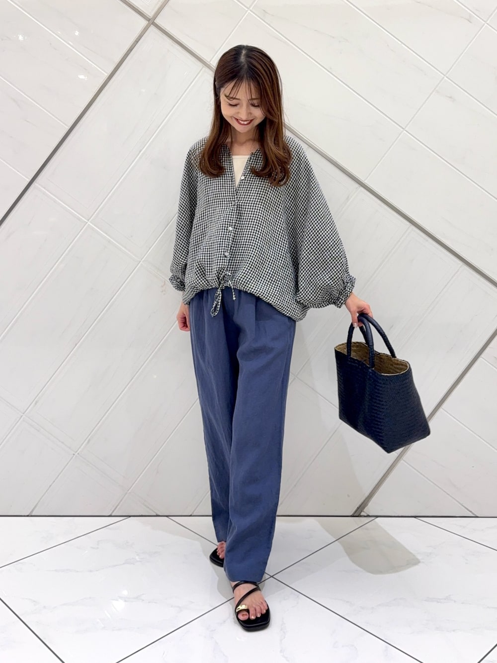 ブルー系のその他パンツ、ブルー系のトートバッグ、ブラック系のサンダルを着用したレディースの夏コーディネートの2枚目の写真