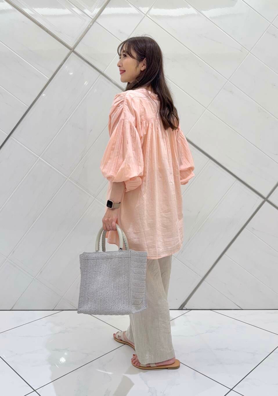 ベージュ系のその他パンツ、グレー系のハンドバッグ、ホワイト系のサンダルを着用したレディースの春コーディネートの5枚目の写真