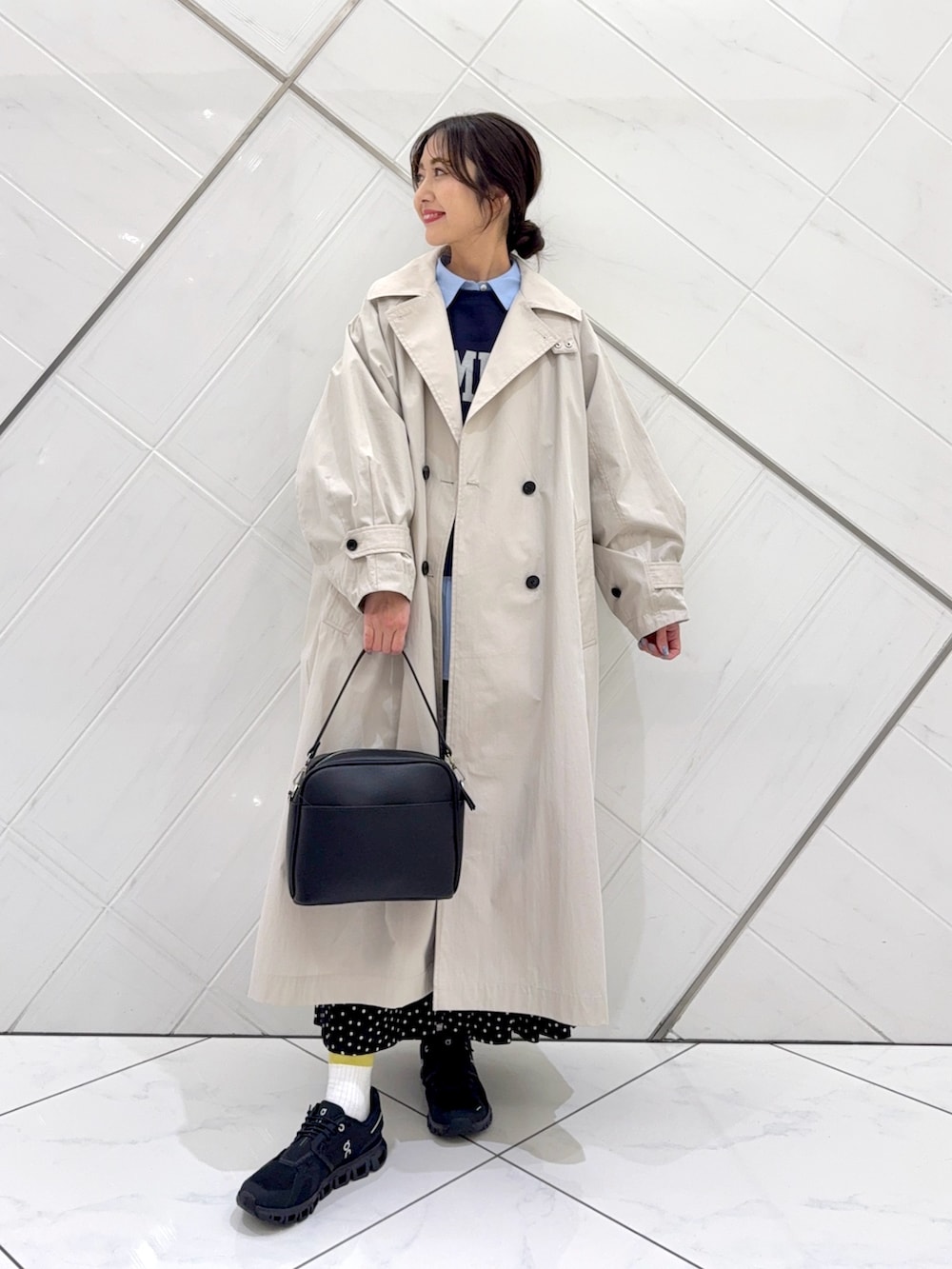 ブルー系のスウェット、ブラック系のスカート、ベージュ系のトレンチコートを着用したレディースの冬コーディネートの3枚目の写真