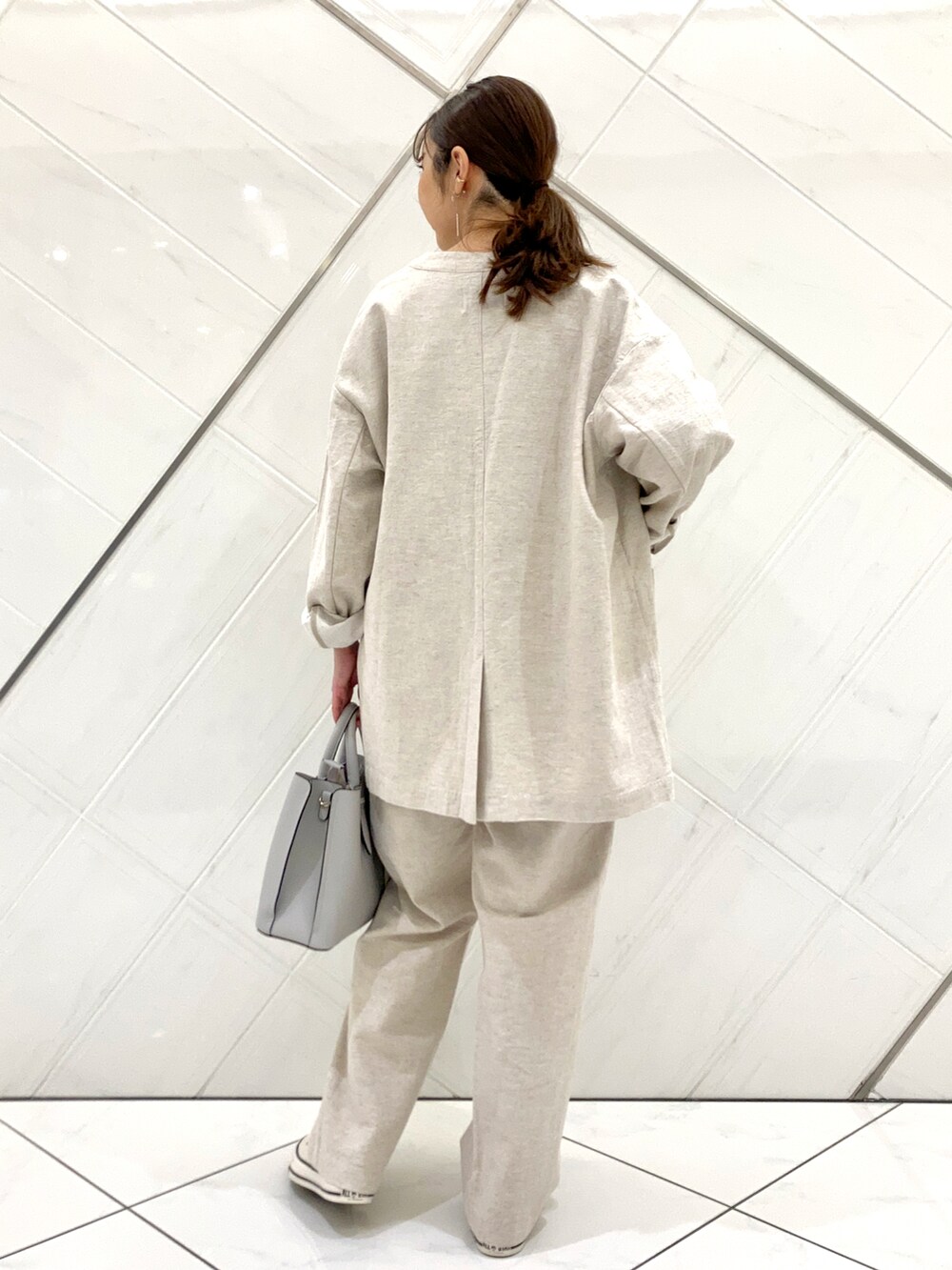 グリーン系のTシャツ/カットソー、ホワイト系のスニーカー、ベージュ系のノーカラージャケットを着用したレディースの春コーディネートの4枚目の写真