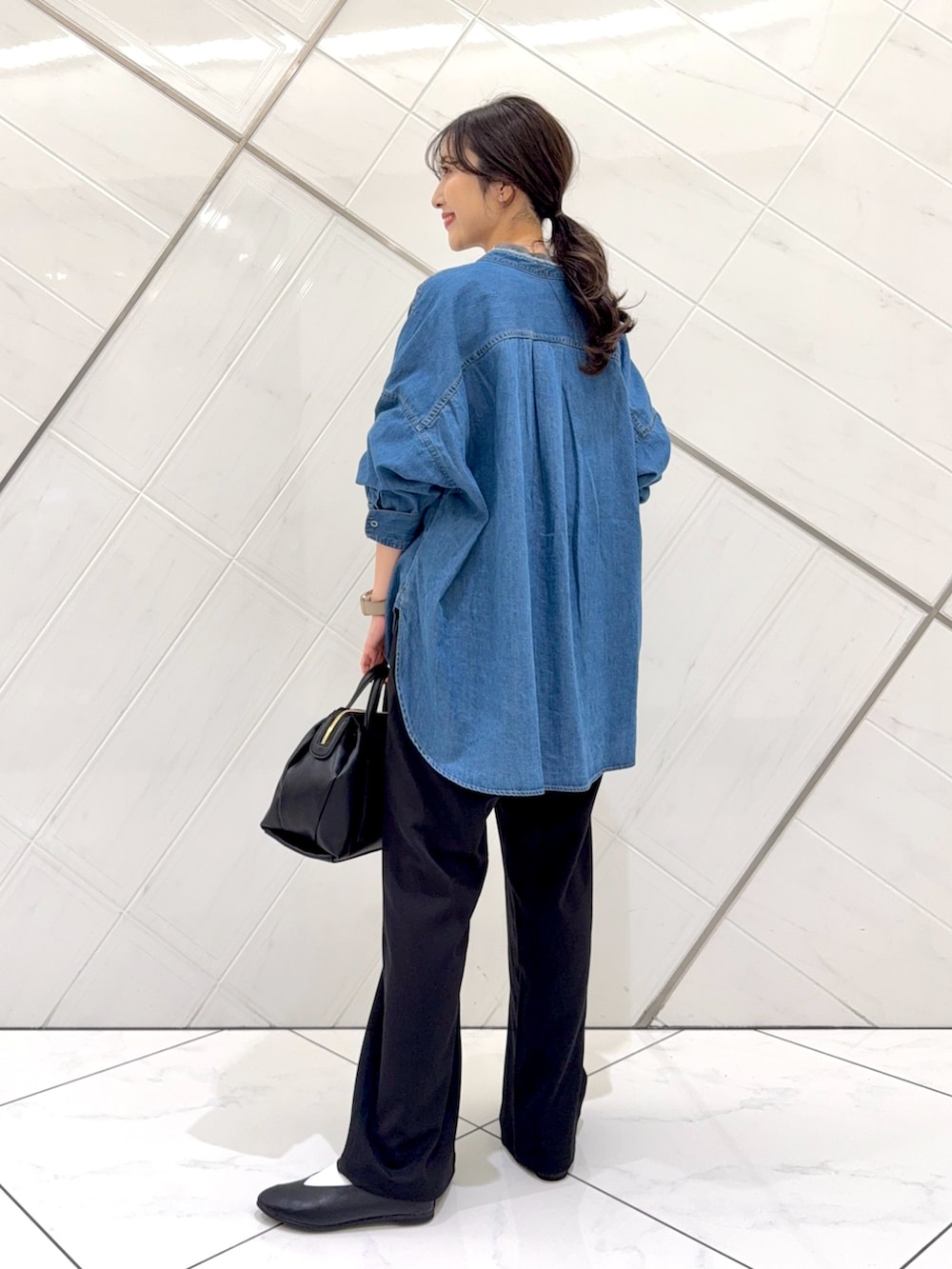 ブルー系のシャツ/ブラウス、グレー系のニット/セーター、ブラック系のその他パンツを着用したレディースの秋コーディネートの3枚目の写真