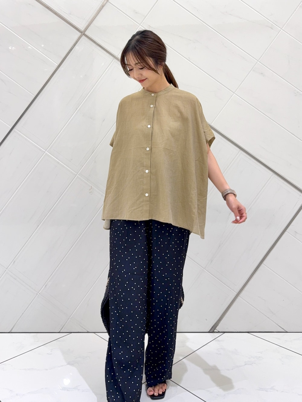 ベージュ系のシャツ/ブラウス、ブルー系のその他パンツ、ブラック系のトートバッグを着用したレディースの夏コーディネートの2枚目の写真