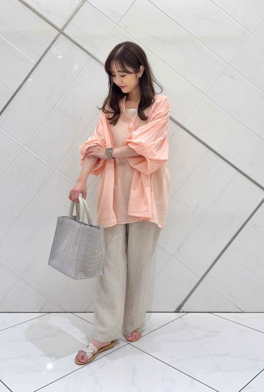 ベージュ系のその他パンツ、グレー系のハンドバッグ、ホワイト系のサンダルを着用したレディースの春コーディネートの2枚目の写真