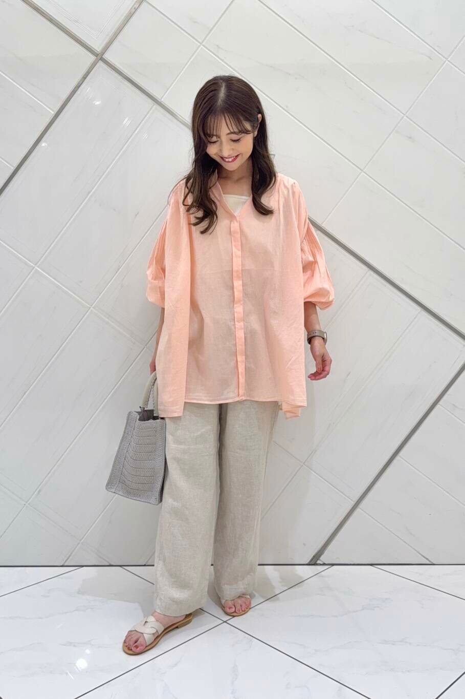 ベージュ系のその他パンツ、グレー系のハンドバッグ、ホワイト系のサンダルを着用したレディースの春コーディネートの3枚目の写真