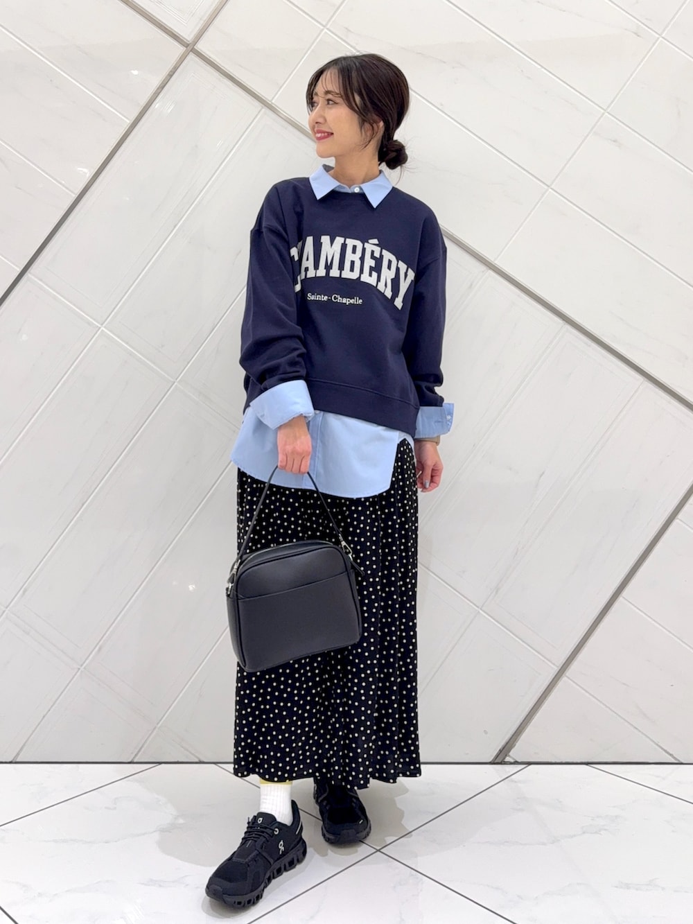 ブルー系のスウェット、ブラック系のスカート、ベージュ系のトレンチコートを着用したレディースの冬コーディネートの5枚目の写真