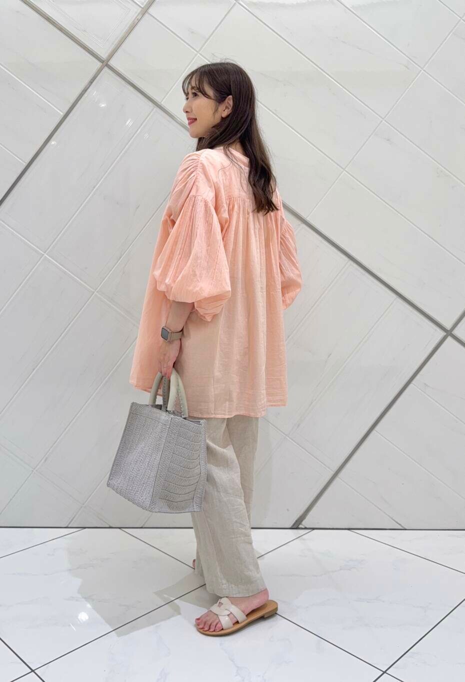 ベージュ系のその他パンツ、グレー系のハンドバッグ、ホワイト系のサンダルを着用したレディースの春コーディネートの4枚目の写真