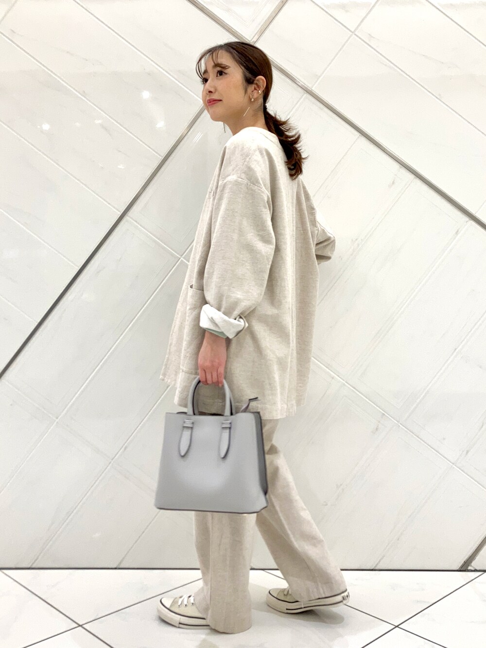 グリーン系のTシャツ/カットソー、ホワイト系のスニーカー、ベージュ系のノーカラージャケットを着用したレディースの春コーディネートの2枚目の写真