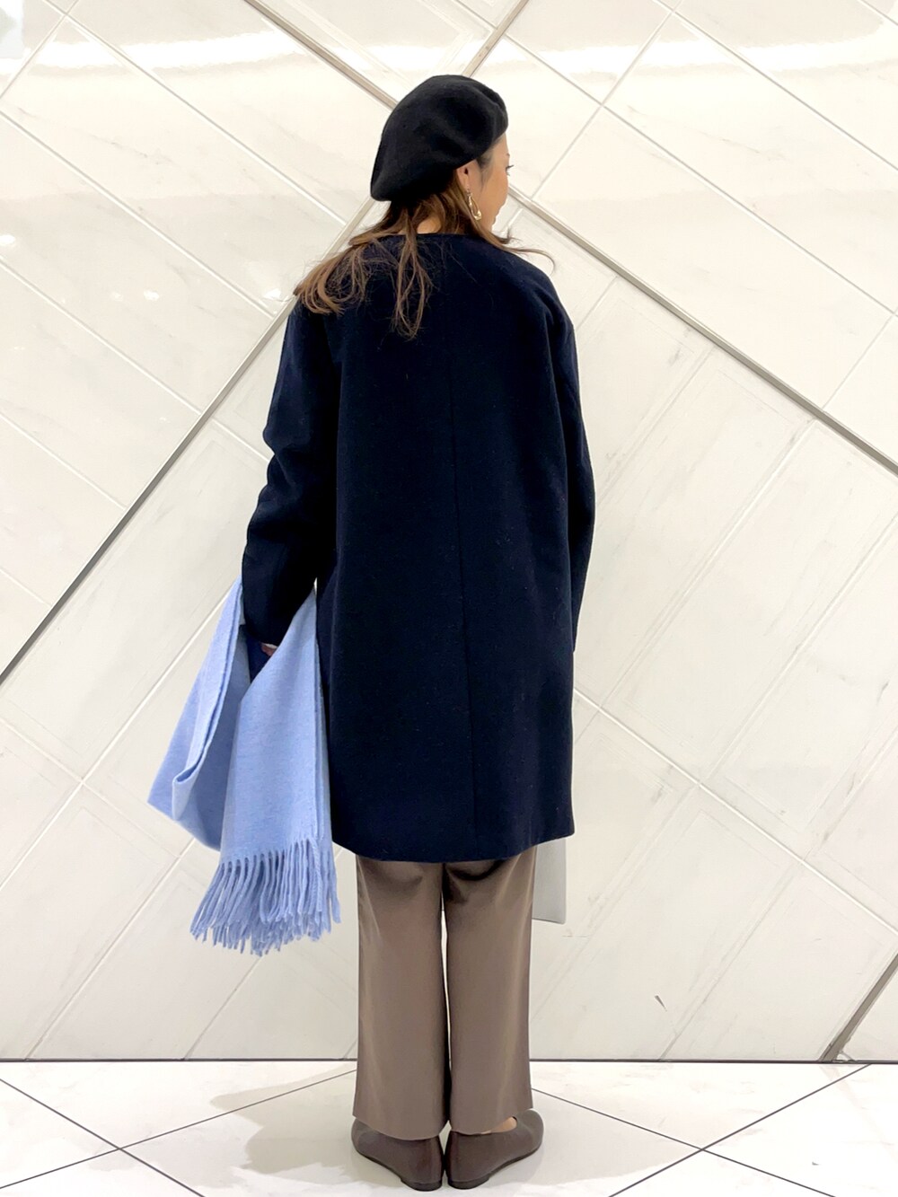 ブラウン系のパンプス、ブルー系のその他アウター、ホワイト系のニット/セーターを着用したレディースの冬コーディネートの3枚目の写真