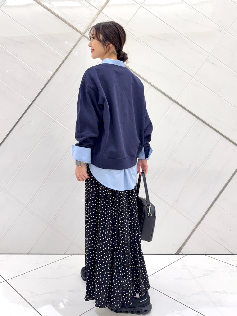 ブルー系のスウェット、ブラック系のスカート、ベージュ系のトレンチコートを着用したレディースの冬コーディネートの8枚目の写真