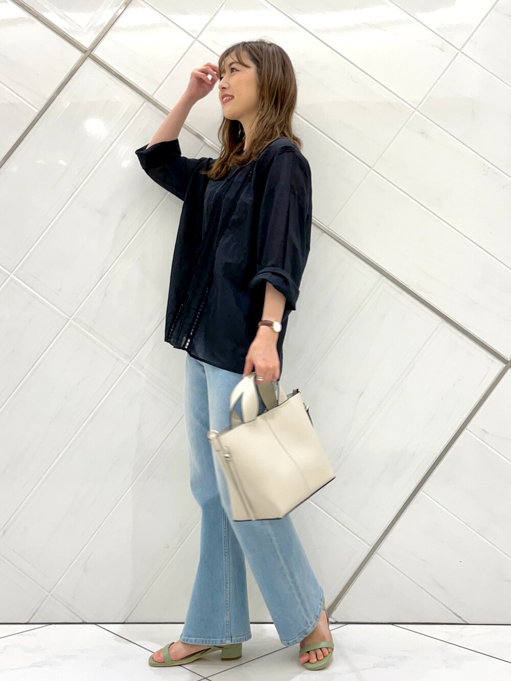 ブルー系のデニムパンツ、グリーン系のサンダル、ブラック系のTシャツ/カットソーを着用したレディースの夏コーディネートの4枚目の写真