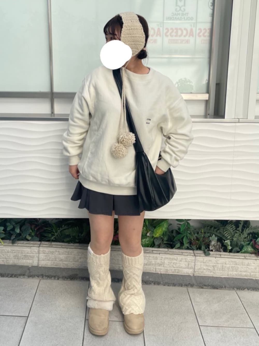 ホワイト系のスウェット、グレー系のスカート、ホワイト系のレッグウォーマーを着用したレディースの冬コーディネートの2枚目の写真