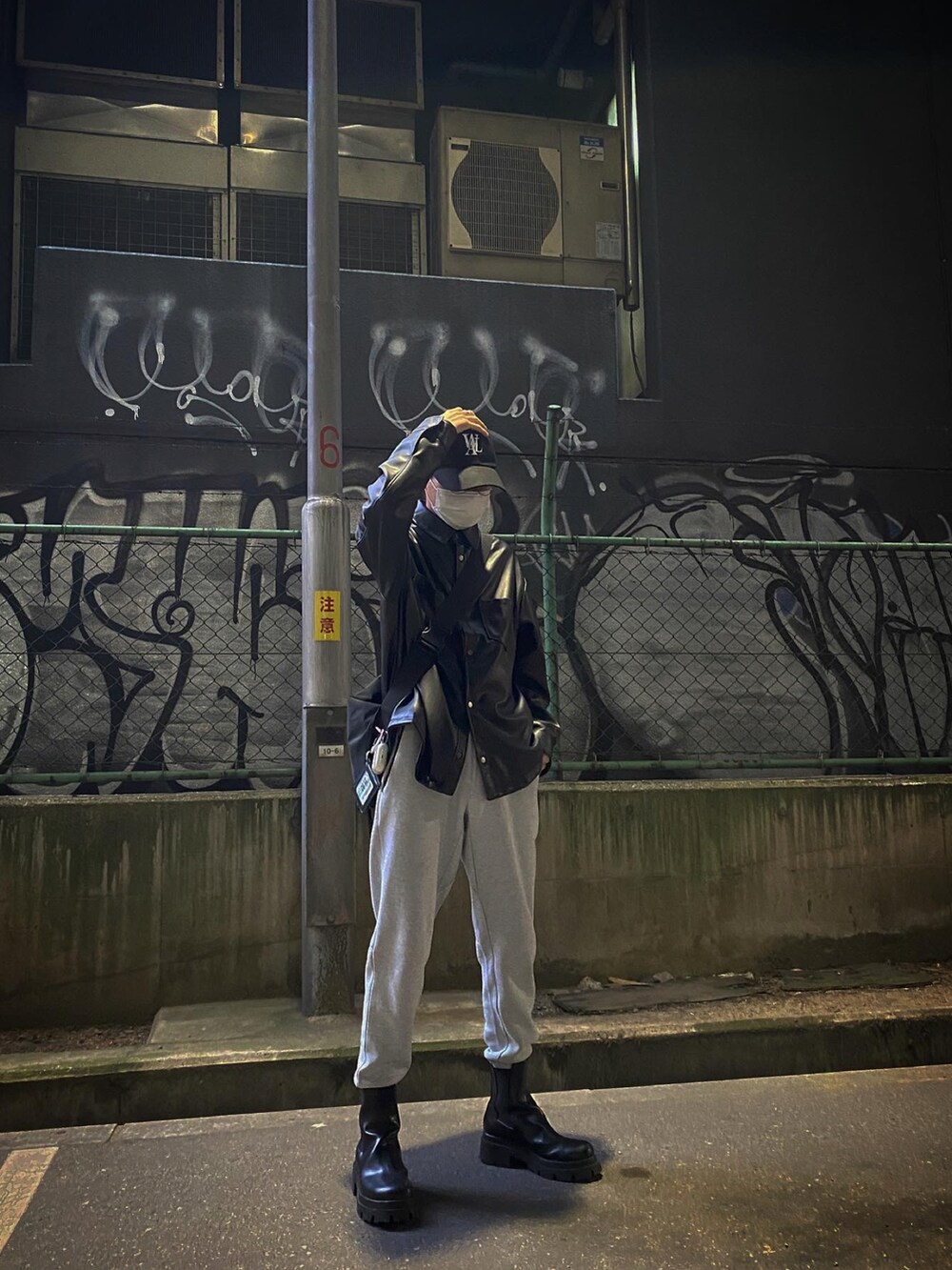 ブラック系のジャケット/アウター、グレー系のスウェットパンツ、ブラック系のブーツを着用したメンズの冬コーディネートの2枚目の写真