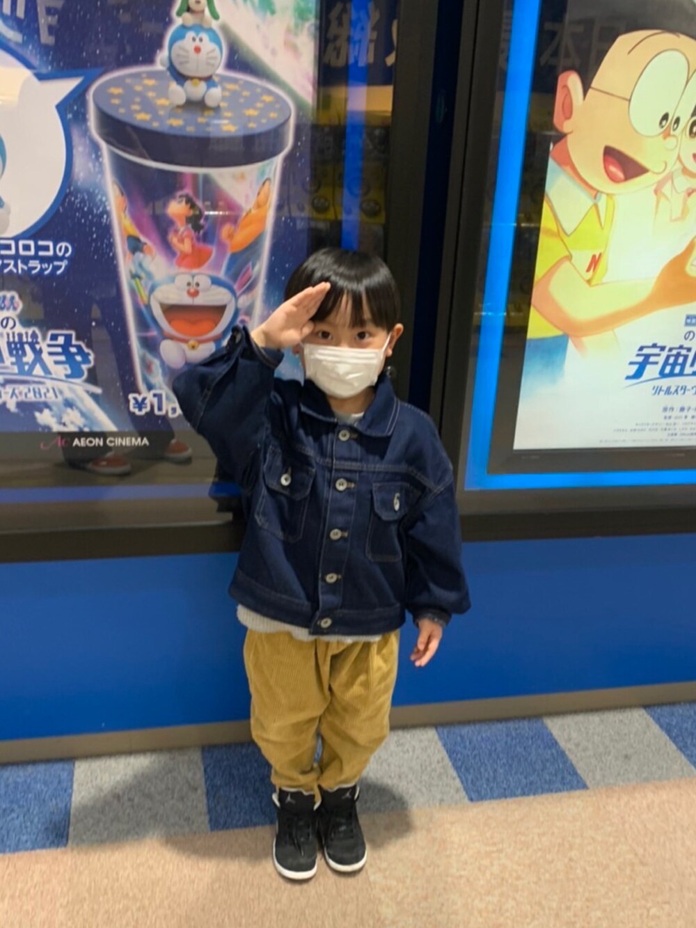 ブルー系のデニムジャケット、ゴールド系のその他パンツ、ブラック系のスニーカーを着用したキッズの春コーディネートの2枚目の写真