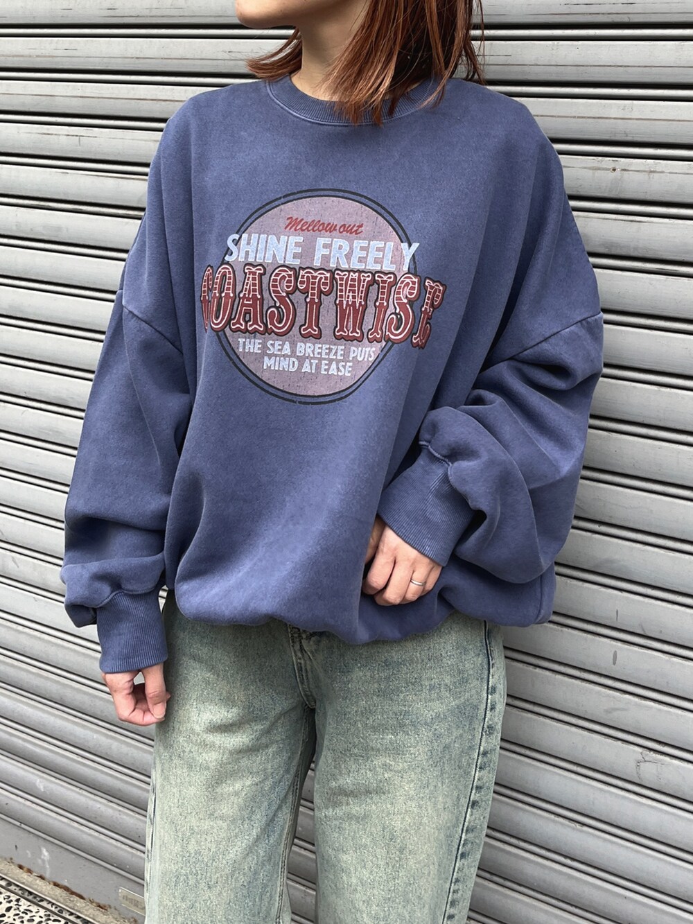 ブルー系のデニムパンツ、ブラウン系のトートバッグ、ブラック系のスニーカーを着用したレディースの冬コーディネートの2枚目の写真