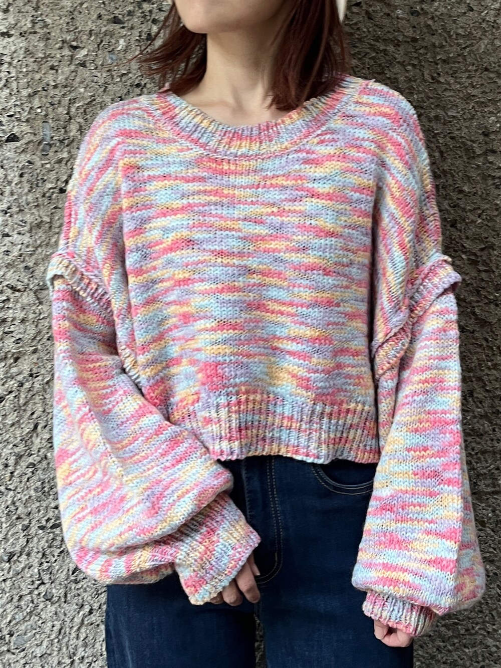 ピンク系のニット/セーター、ブルー系のデニムパンツ、ブラック系のスニーカーを着用したレディースの秋コーディネートの2枚目の写真