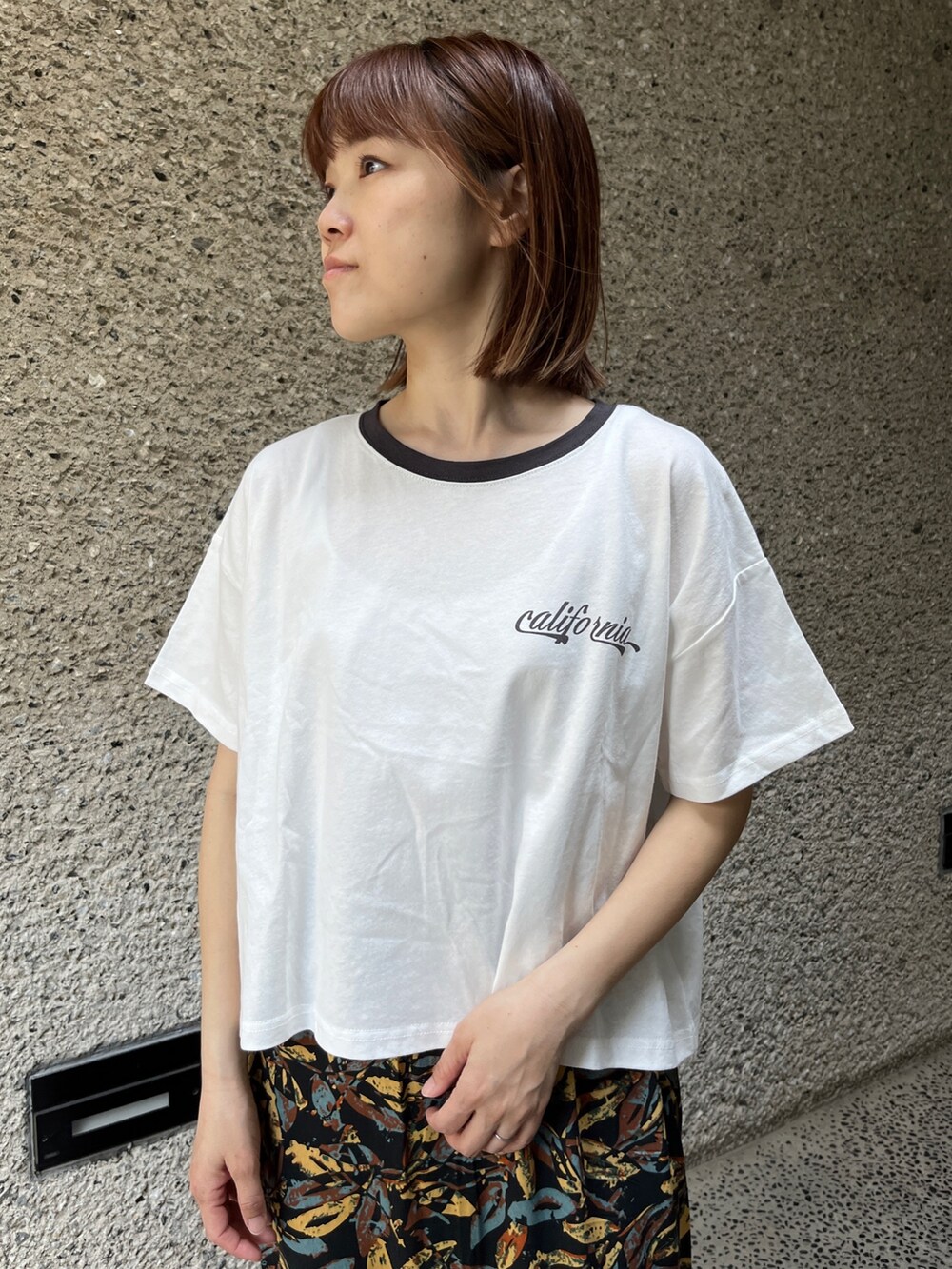 ホワイト系のTシャツ/カットソー、グレー系のスカート、ホワイト系のスニーカーを着用したレディースの春コーディネートの4枚目の写真