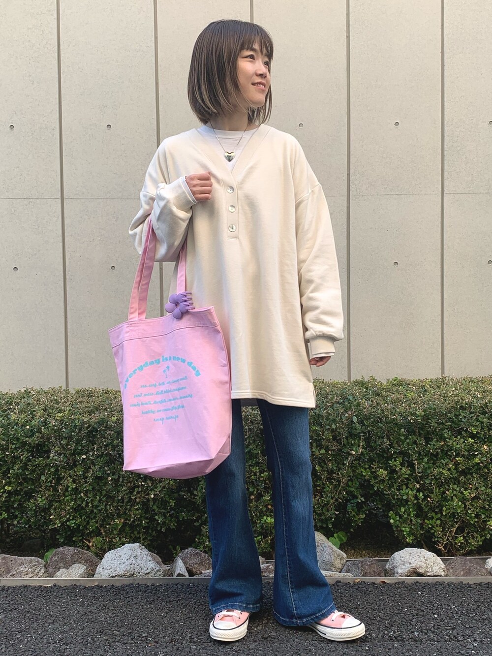 ベージュ系のワンピース、ピンク系のスニーカー、シルバー系のネックレスを着用したレディースの冬コーディネートの3枚目の写真