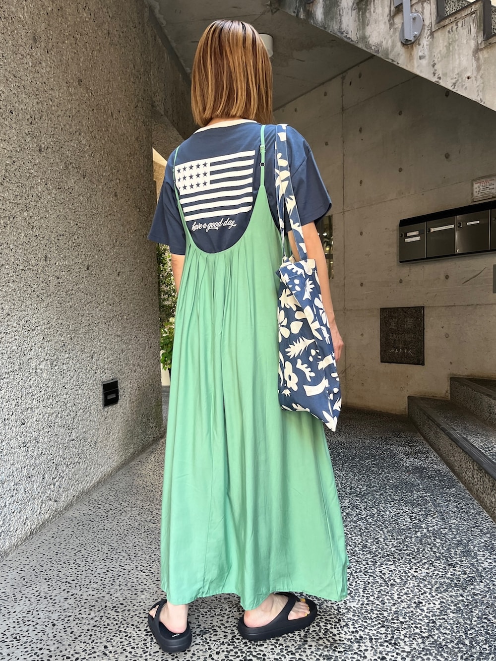グリーン系のワンピース、ブルー系のTシャツ/カットソー、ブラック系のサンダルを着用したレディースの夏コーディネートの3枚目の写真