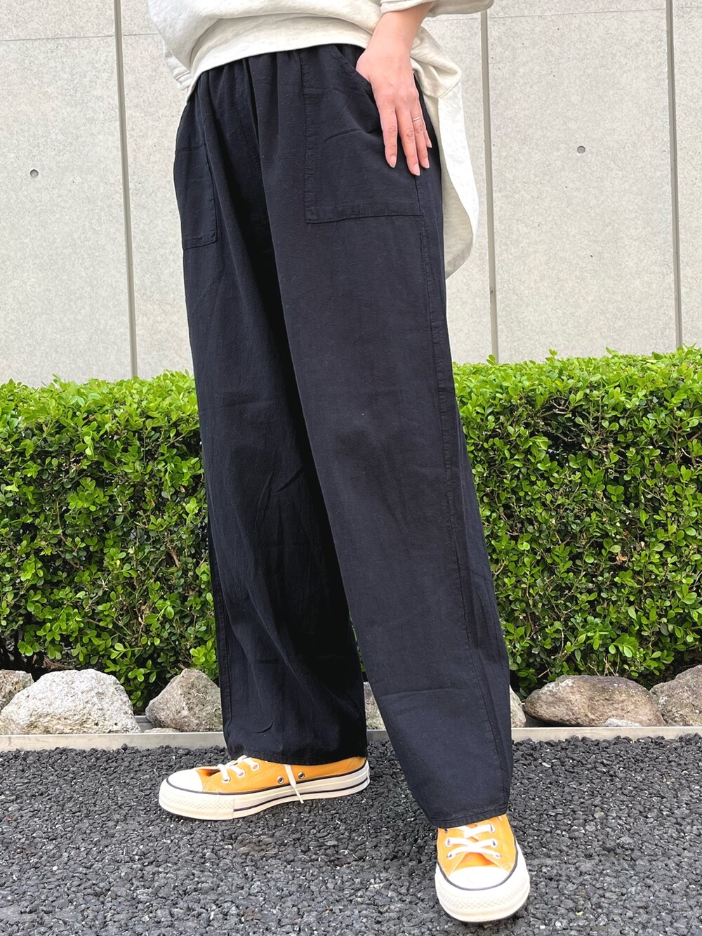 ブラック系のその他パンツ、ホワイト系のTシャツ/カットソー、イエロー系のスニーカーを着用したレディースの春コーディネートの8枚目の写真