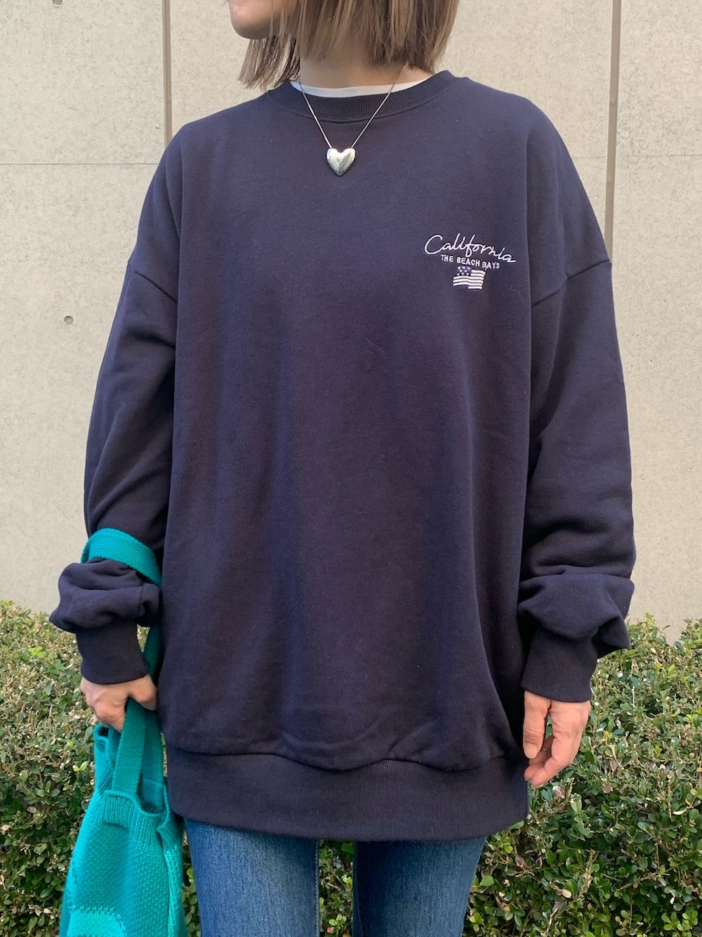 ブルー系のスウェット、ブルー系のトートバッグ、イエロー系のスニーカーを着用したレディースの冬コーディネートの2枚目の写真