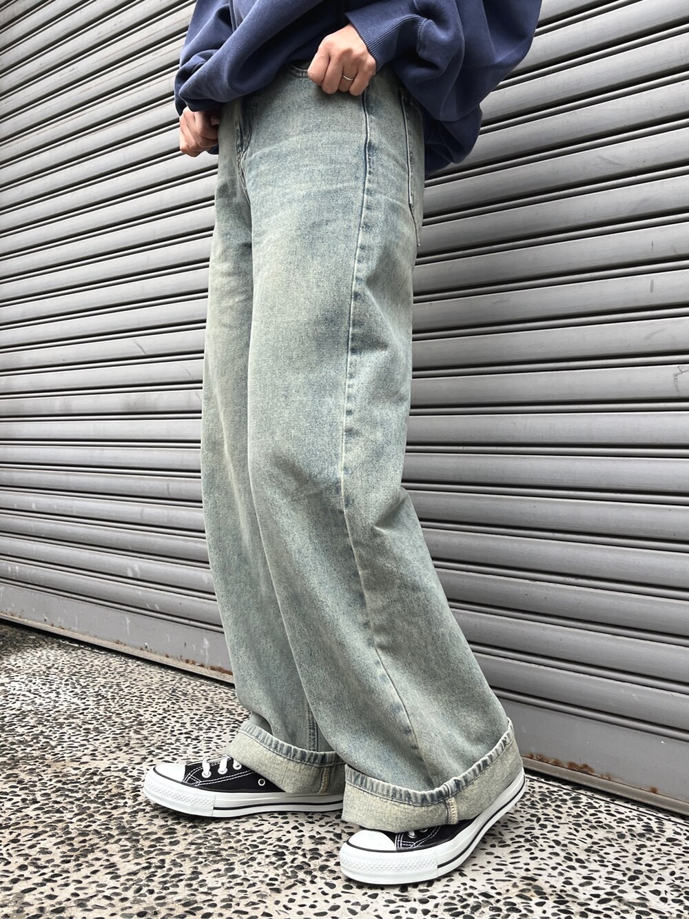 ブルー系のデニムパンツ、ブラウン系のトートバッグ、ブラック系のスニーカーを着用したレディースの冬コーディネートの5枚目の写真