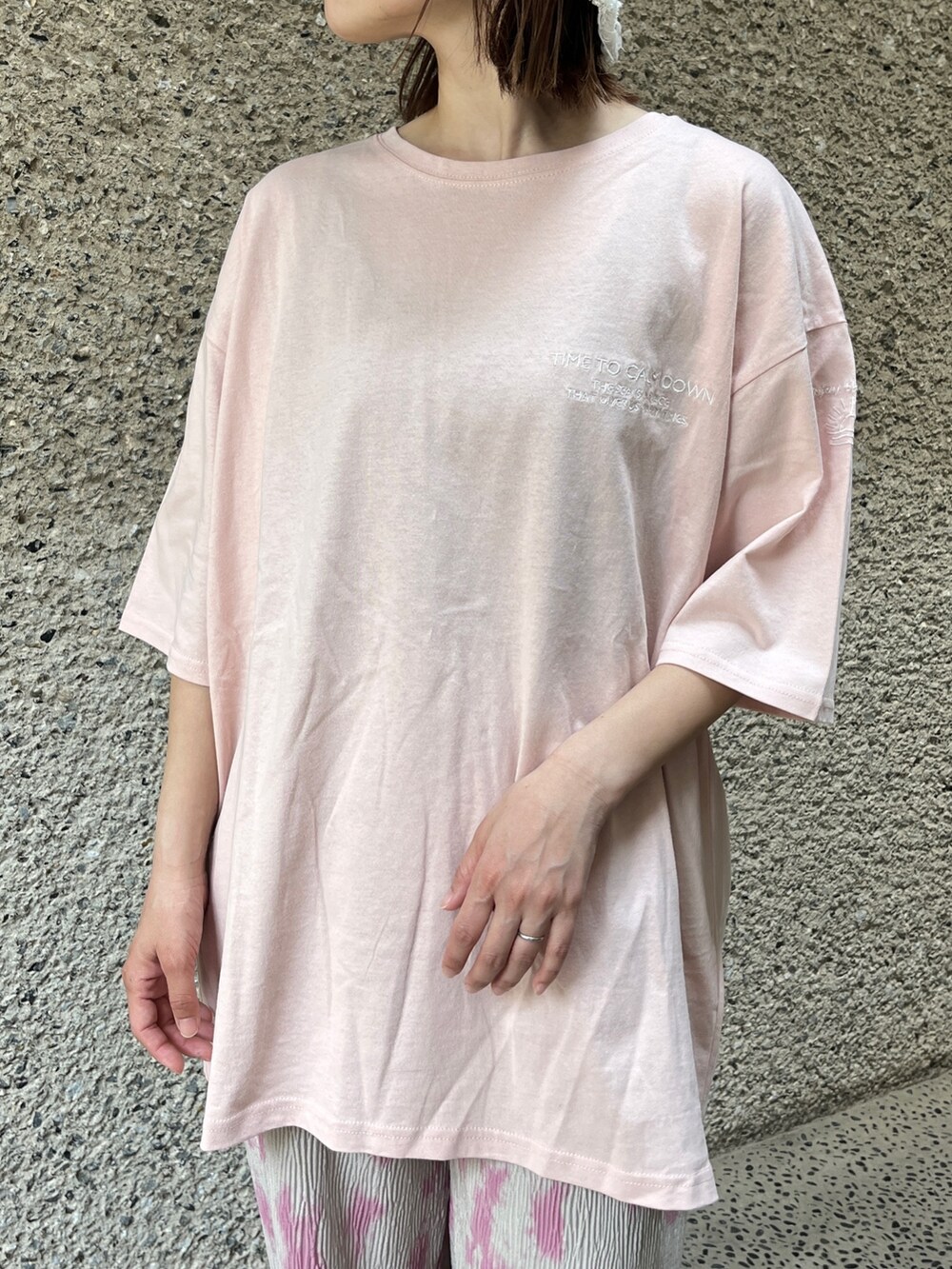 ピンク系のTシャツ/カットソー、グレー系のその他パンツ、ホワイト系のスニーカーを着用したレディースの春コーディネートの4枚目の写真