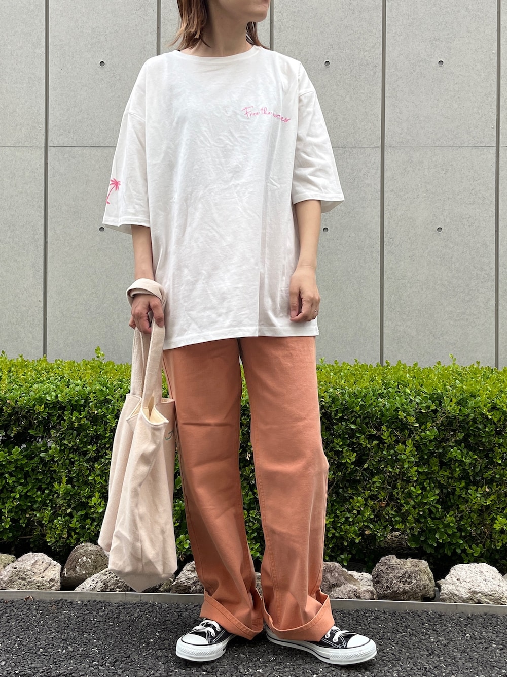 ホワイト系のTシャツ/カットソー、オレンジ系のデニムパンツ、ベージュ系のトートバッグを着用したレディースの春コーディネートの2枚目の写真