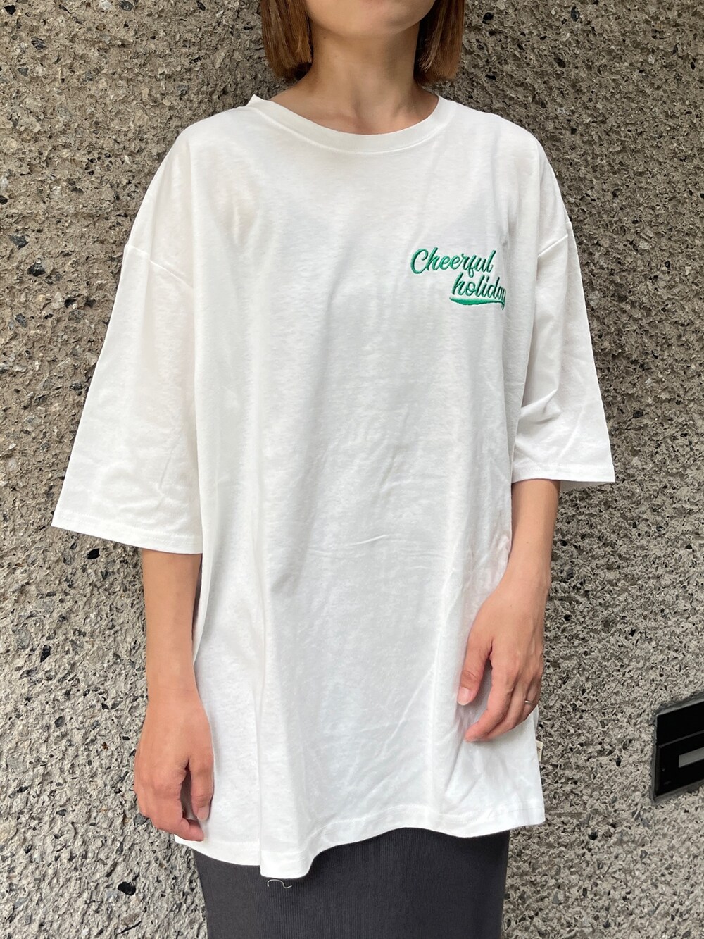 ホワイト系のTシャツ/カットソー、グレー系のスカート、ブラック系のトートバッグを着用したレディースの夏コーディネートの3枚目の写真