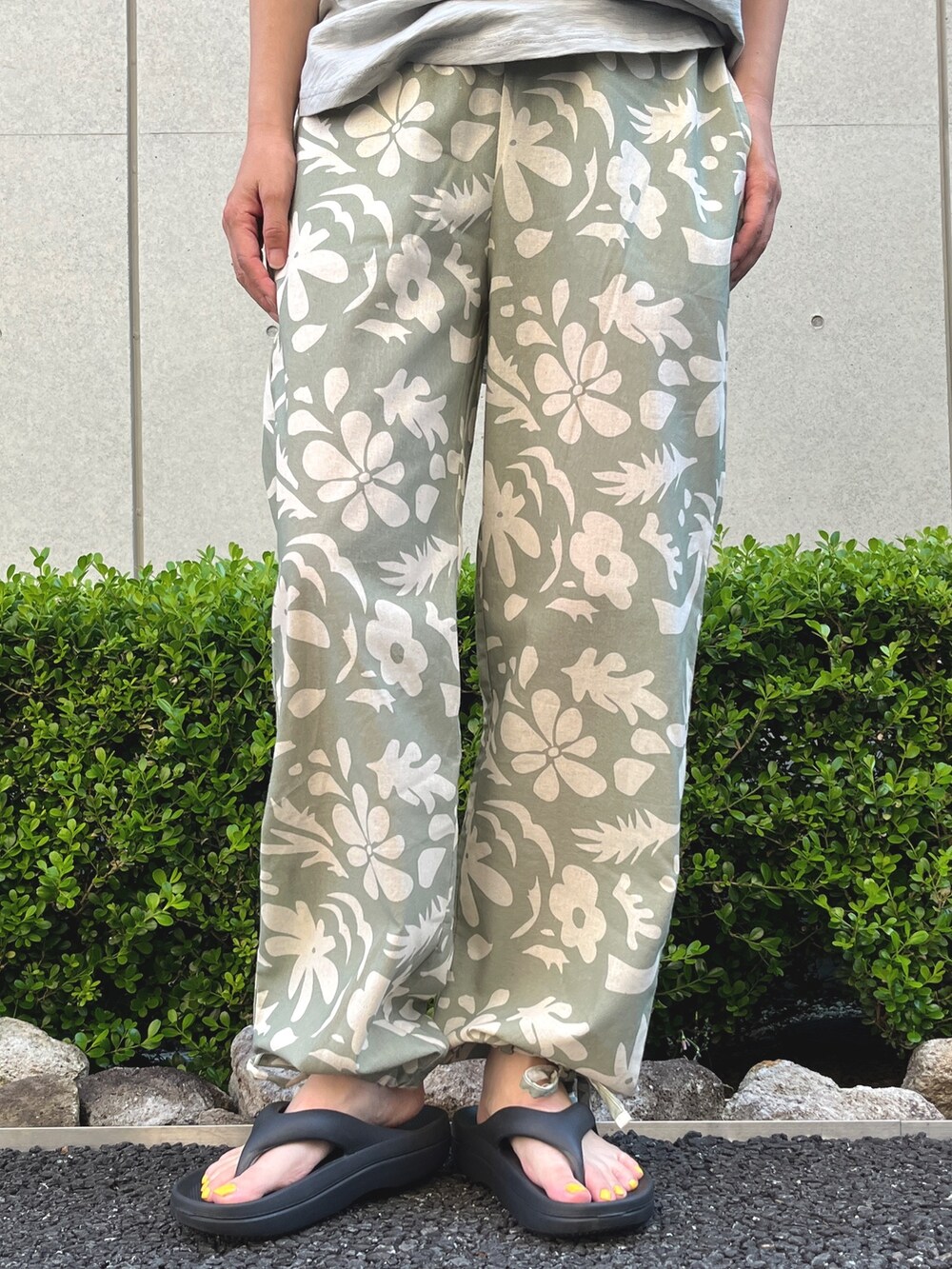 グリーン系のTシャツ/カットソー、ブラック系のサンダル、ブラック系のトートバッグを着用したレディースの夏コーディネートの3枚目の写真