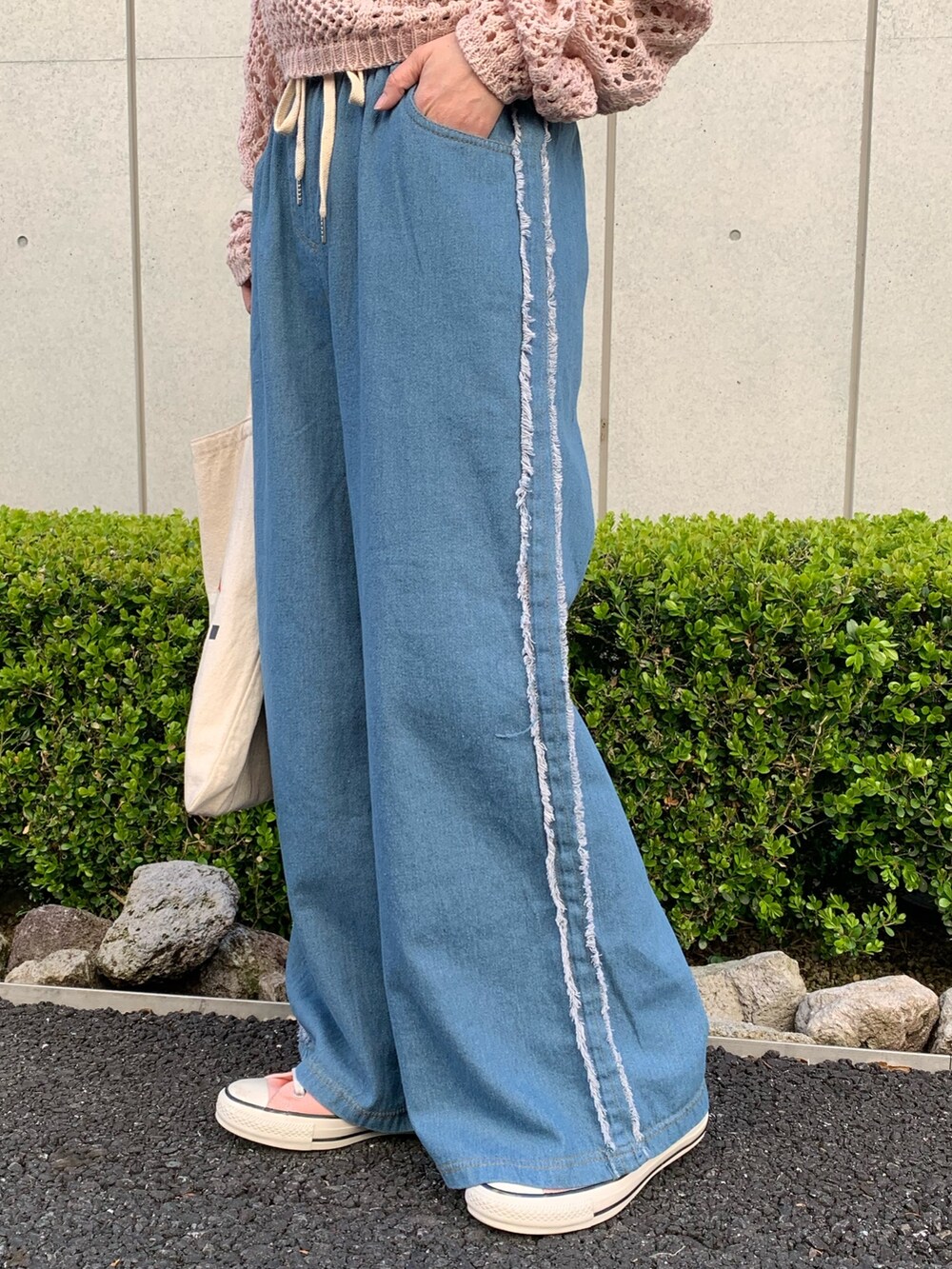 ピンク系のTシャツ/カットソー、ブルー系のデニムパンツ、ホワイト系のバッグを着用したレディースの春コーディネートの7枚目の写真