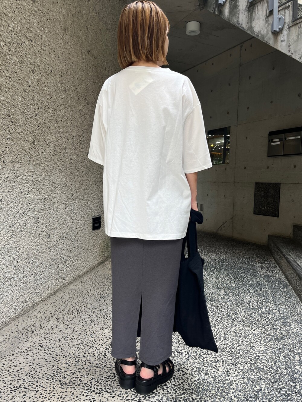 ホワイト系のTシャツ/カットソー、グレー系のスカート、ブラック系のトートバッグを着用したレディースの夏コーディネートの2枚目の写真
