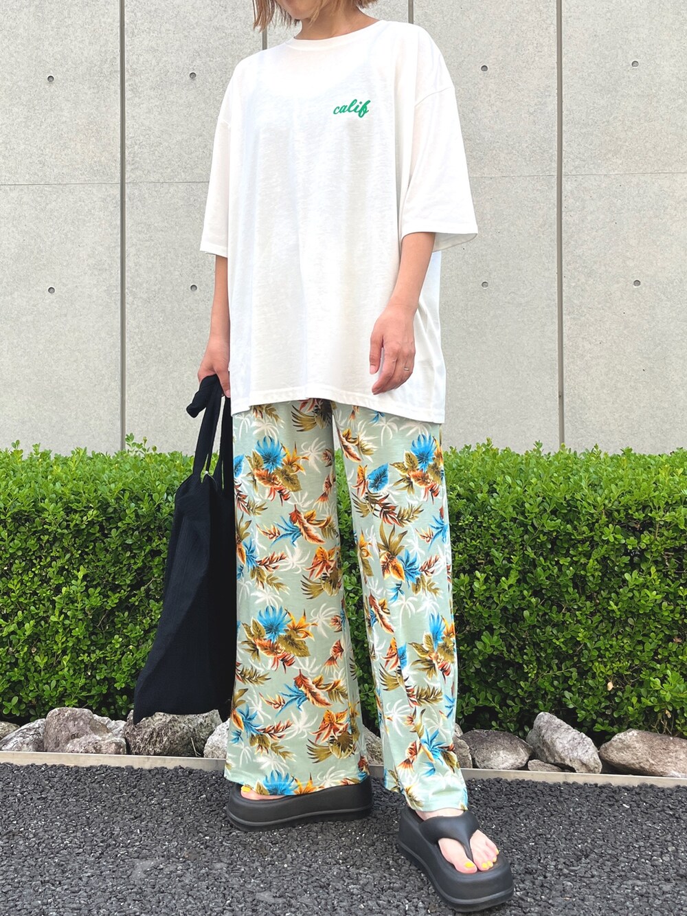 ホワイト系のTシャツ/カットソー、グリーン系のその他パンツ、ブラック系のサンダルを着用したレディースの夏コーディネートの2枚目の写真