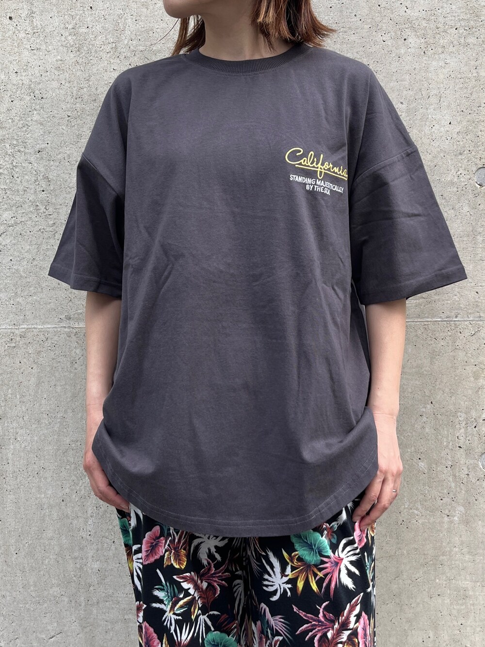 グレー系のTシャツ/カットソー、ブルー系のトートバッグ、ブラック系のスニーカーを着用したレディースの春コーディネートの3枚目の写真