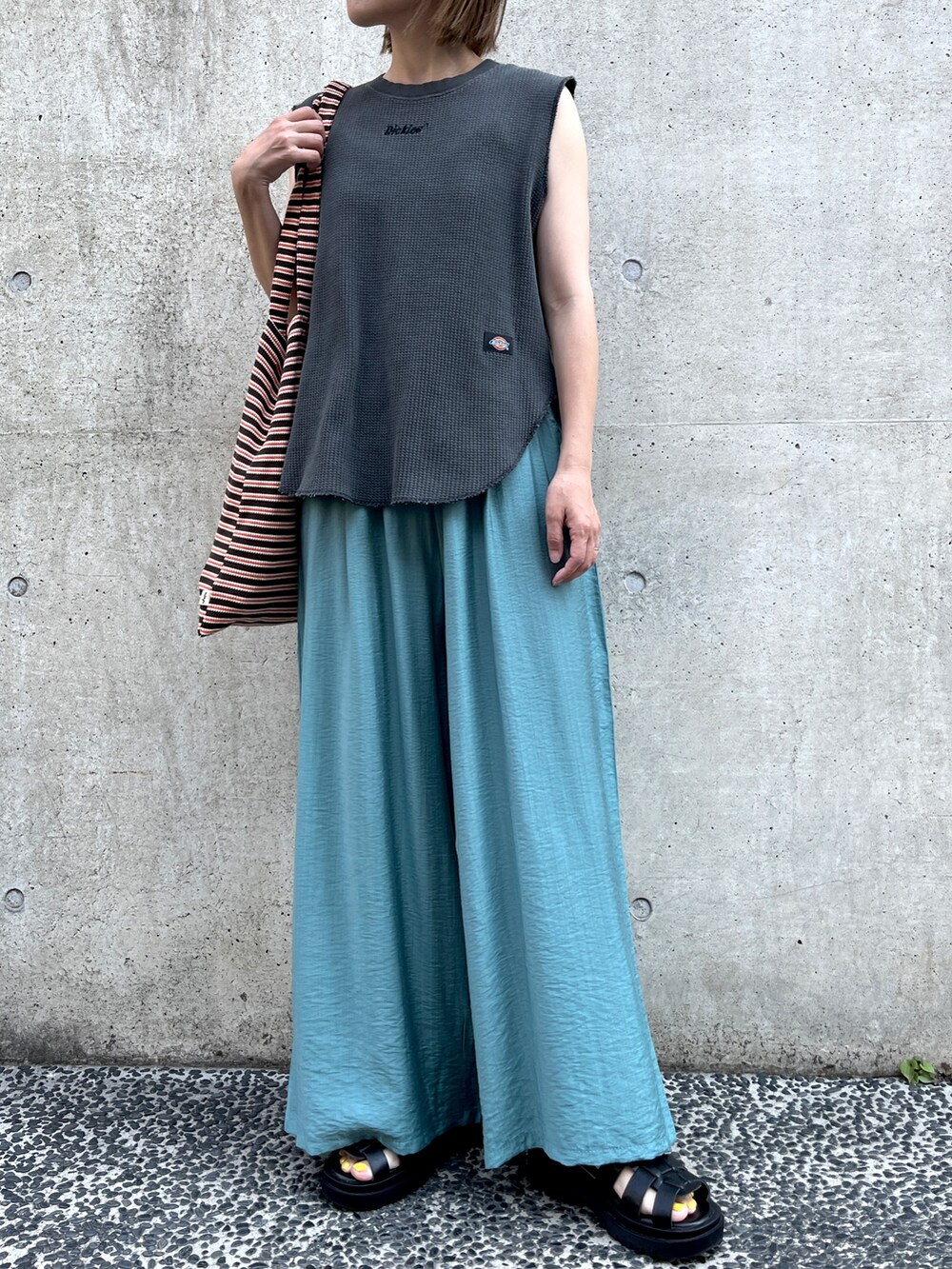 ブラック系のTシャツ/カットソー、ブルー系のその他パンツ、ブラウン系のトートバッグを着用したレディースの夏コーディネートの2枚目の写真