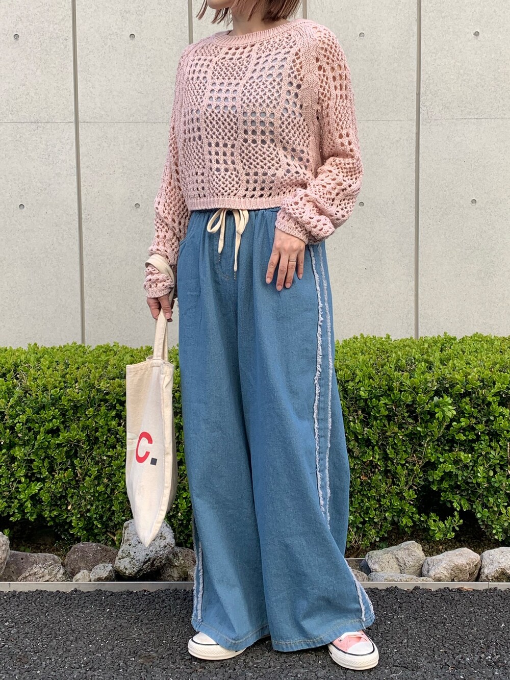 ピンク系のTシャツ/カットソー、ブルー系のデニムパンツ、ホワイト系のバッグを着用したレディースの春コーディネートの2枚目の写真