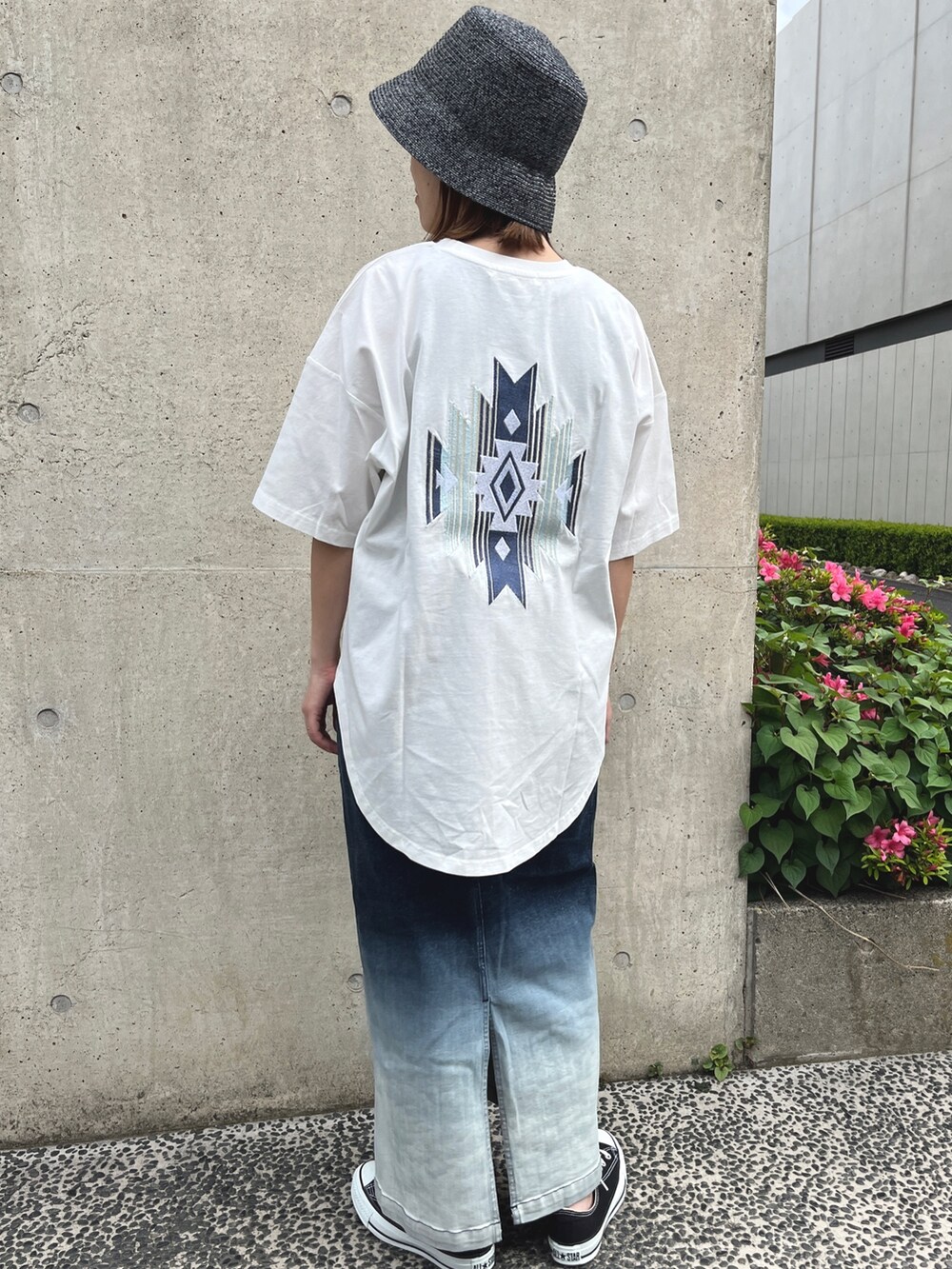 ホワイト系のTシャツ/カットソー、ブルー系のスカート、ブラック系のスニーカーを着用したレディースの春コーディネートの2枚目の写真