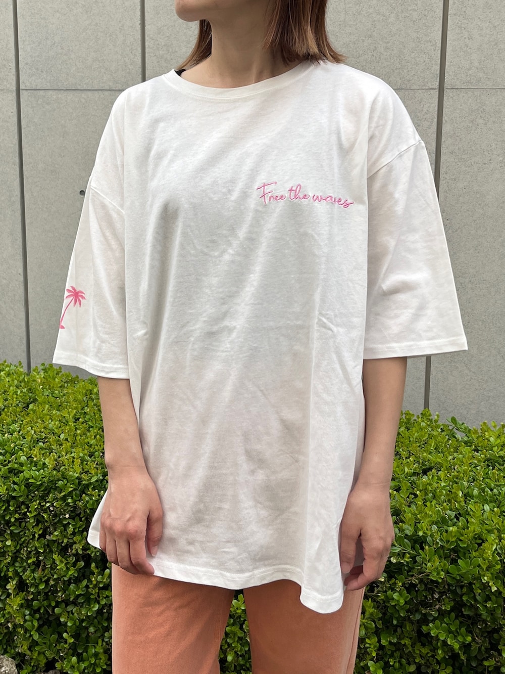 ホワイト系のTシャツ/カットソー、オレンジ系のデニムパンツ、ベージュ系のトートバッグを着用したレディースの春コーディネートの5枚目の写真