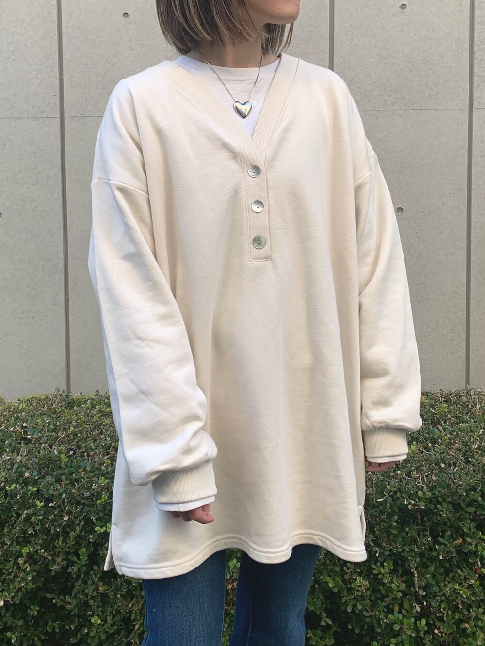 ベージュ系のワンピース、ピンク系のスニーカー、シルバー系のネックレスを着用したレディースの冬コーディネートの4枚目の写真