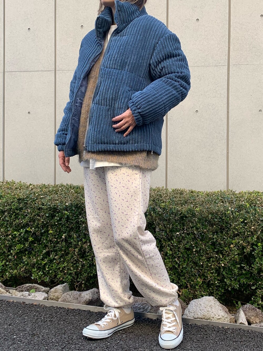 ブルー系のダウンジャケット/コート、ベージュ系のカーディガン/ボレロ、ホワイト系のスウェットパンツを着用したレディースの冬コーディネートの2枚目の写真