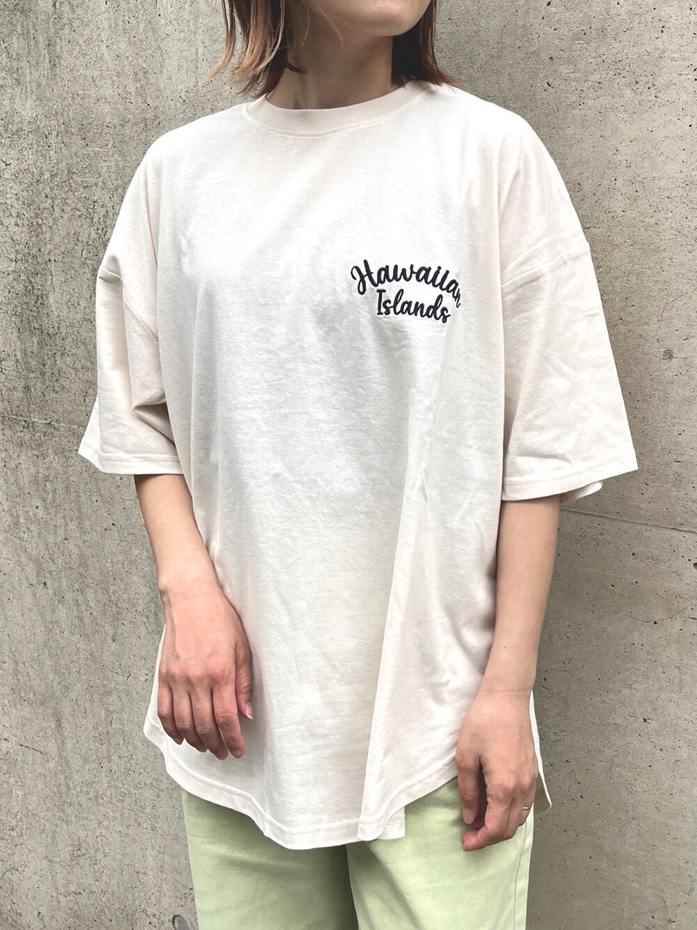 ベージュ系のスニーカー、グリーン系のデニムパンツ、ブルー系のトートバッグを着用したレディースの春コーディネートの3枚目の写真