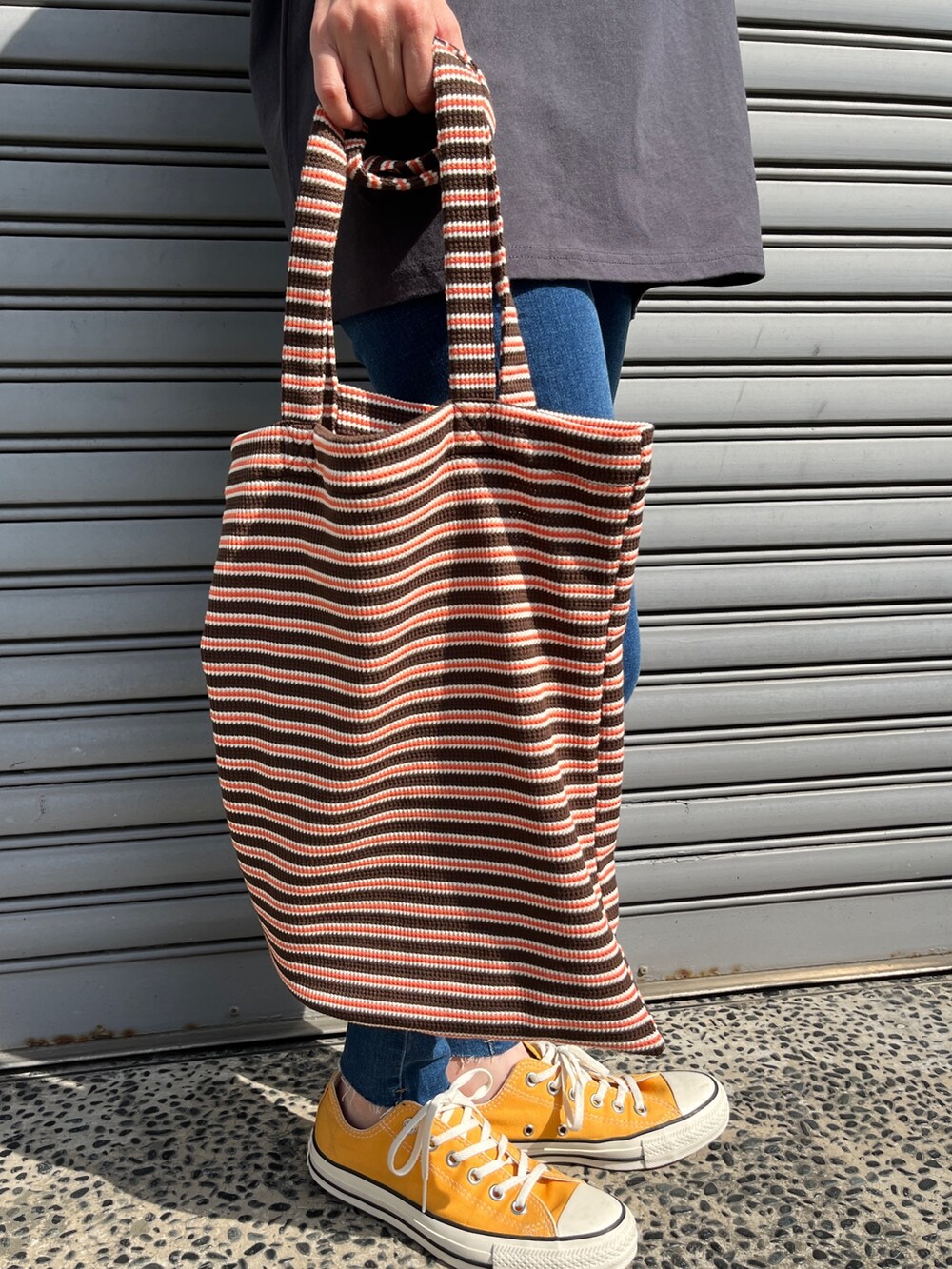 ブルー系のデニムパンツ、グレー系のTシャツ/カットソー、イエロー系のスニーカーを着用したレディースの春コーディネートの3枚目の写真