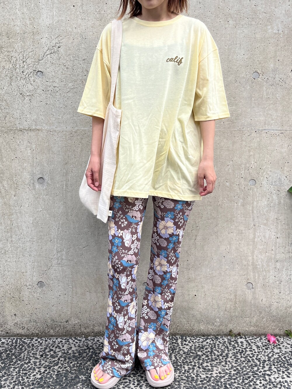 イエロー系のTシャツ/カットソー、ベージュ系のトートバッグ、ベージュ系のサンダルを着用したレディースの夏コーディネートの2枚目の写真