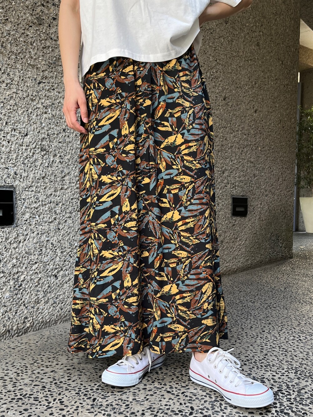 ホワイト系のTシャツ/カットソー、グレー系のスカート、ホワイト系のスニーカーを着用したレディースの春コーディネートの6枚目の写真