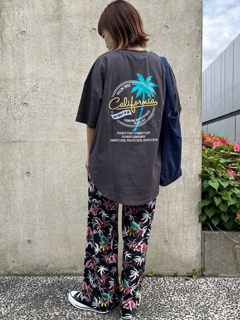 グレー系のTシャツ/カットソー、ブルー系のトートバッグ、ブラック系のスニーカーを着用したレディースの春コーディネートの2枚目の写真