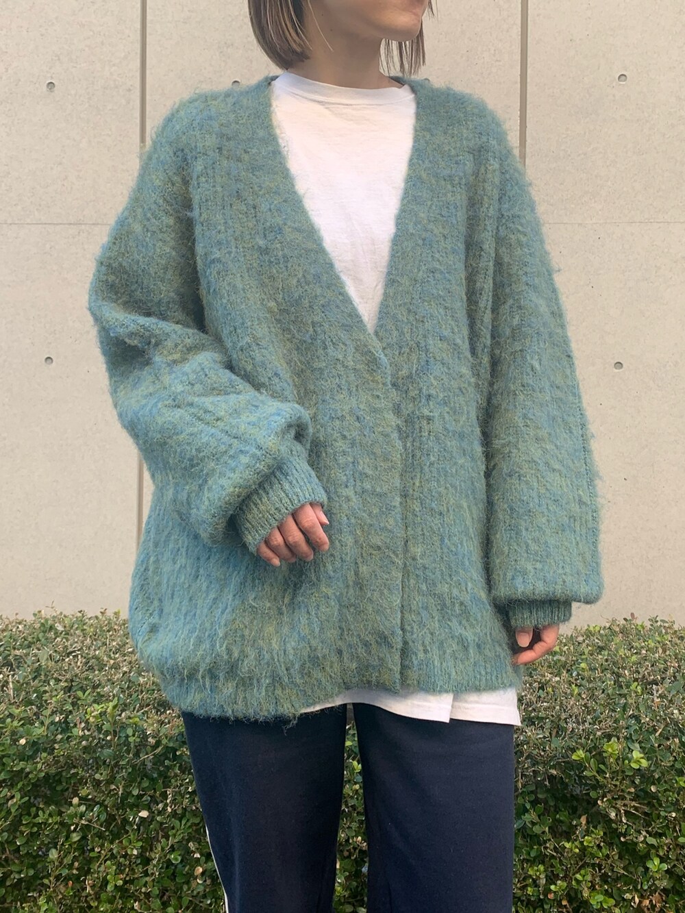 ブルー系のカーディガン/ボレロ、ブルー系のスウェットパンツ、ブラック系のシューズを着用したレディースの冬コーディネートの2枚目の写真