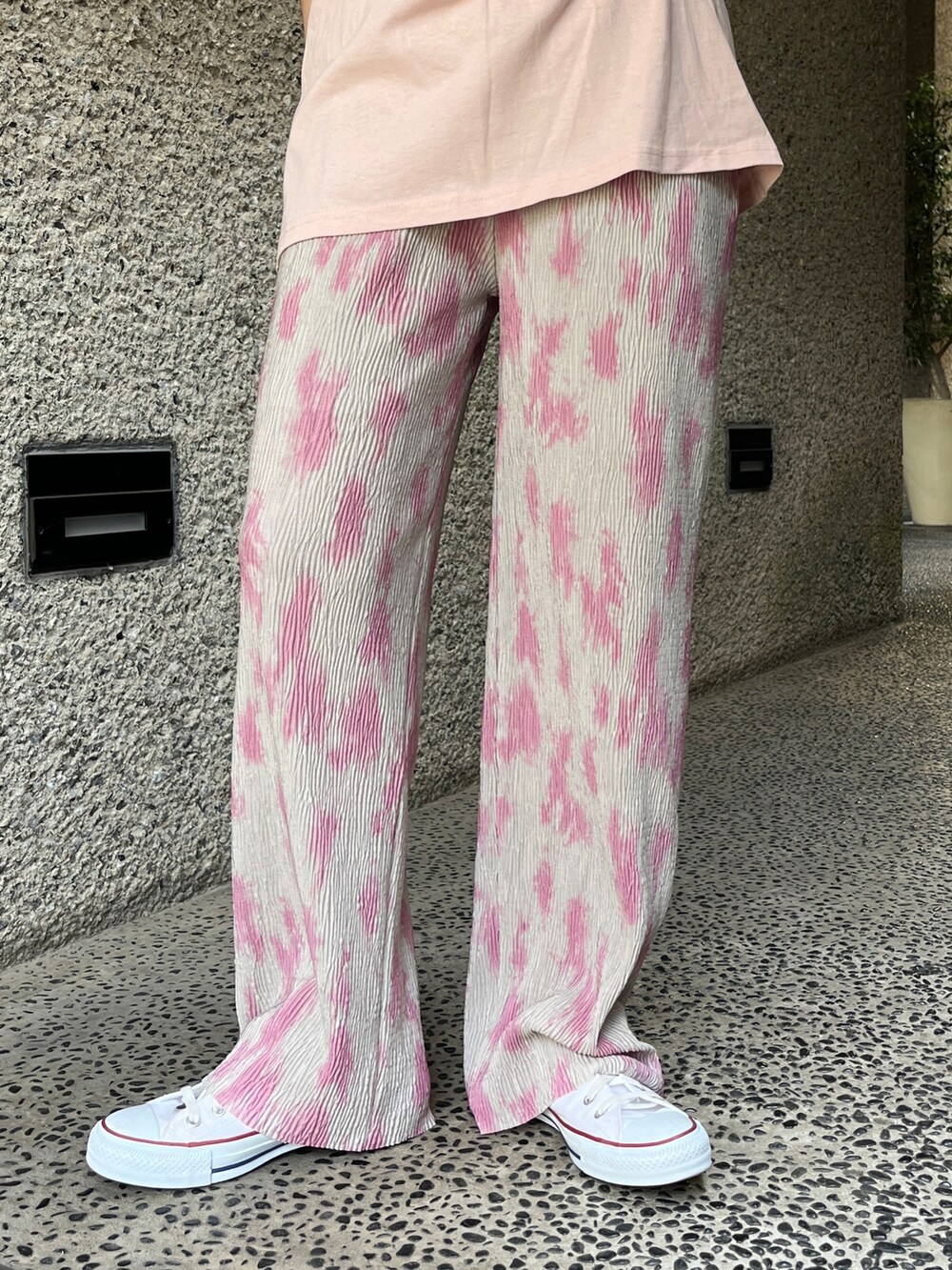 ピンク系のTシャツ/カットソー、グレー系のその他パンツ、ホワイト系のスニーカーを着用したレディースの春コーディネートの6枚目の写真