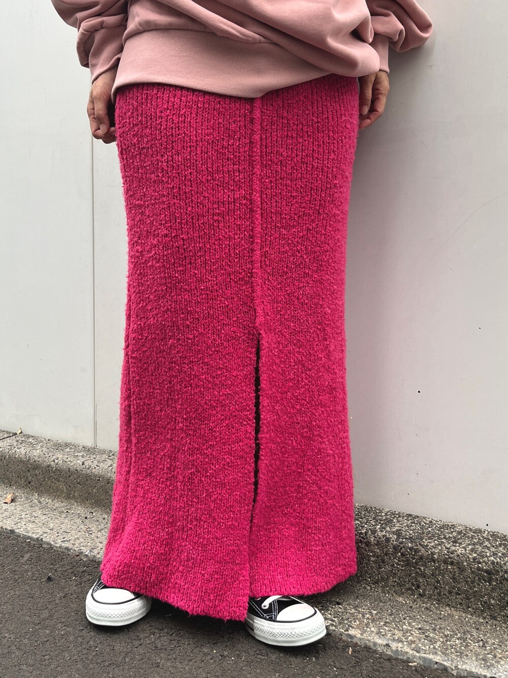 ピンク系のパーカー、ピンク系のスカート、ホワイト系のショルダーバッグを着用したレディースの秋コーディネートの3枚目の写真