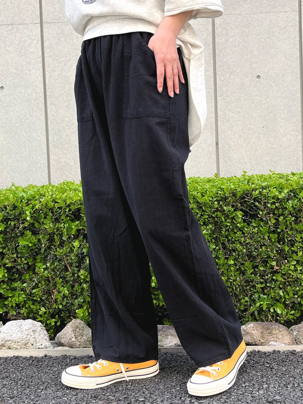 ブラック系のその他パンツ、ホワイト系のTシャツ/カットソー、イエロー系のスニーカーを着用したレディースの春コーディネートの7枚目の写真