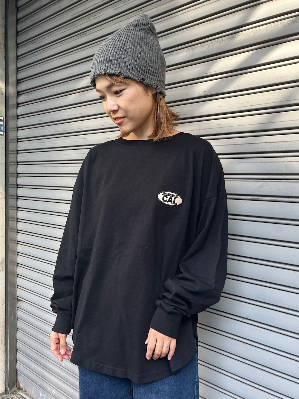 ブラック系のTシャツ/カットソー、ブルー系のデニムパンツ、ブラック系のスニーカーを着用したレディースの秋コーディネートの3枚目の写真