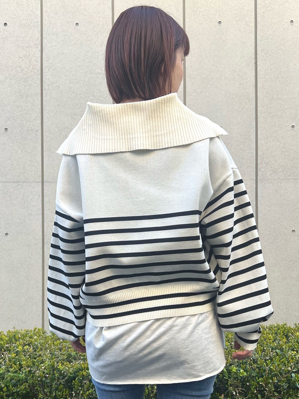 ホワイト系のニット/セーター、ブルー系のデニムパンツを着用したレディースの春コーディネートの4枚目の写真